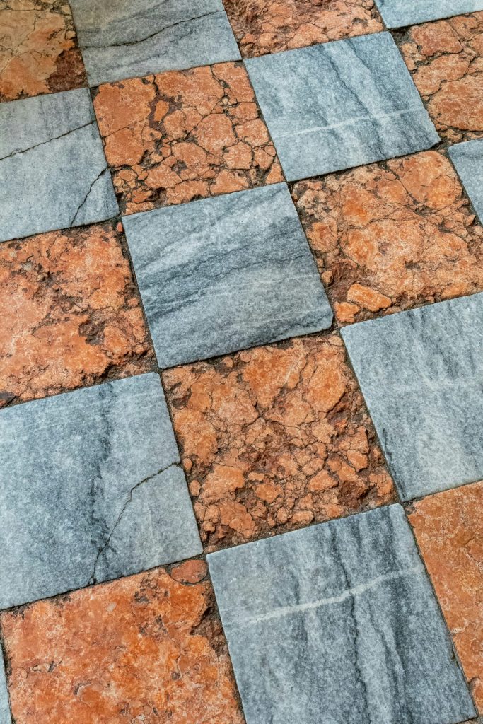 a close up of a tiled floor with a teddy bear